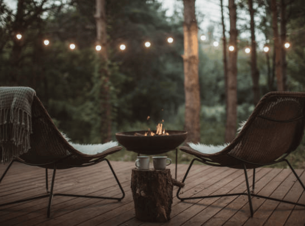 2 chaises, 2 tasses et un brasero sur une terrasse d'un ecolodge en pleine forêt en Île-de-France